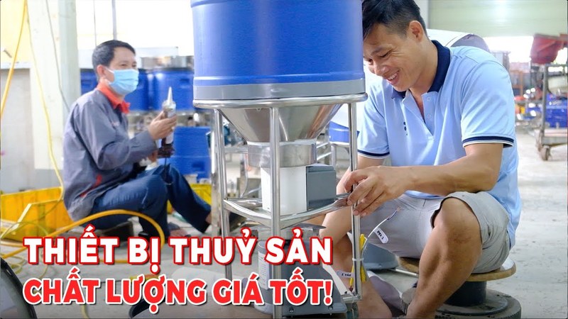 Ảnh bìa clip xưởng sản xuất máy cho tôm ăn và máy bơm nước FarmX, hai thợ đang lắp máy phễu xanh trong xưởng