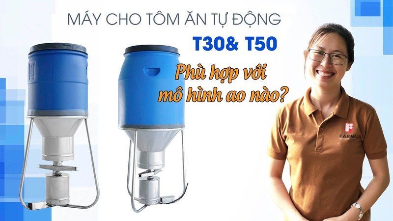 Ảnh bìa clip máy cho tôm ăn tự động T30 và T50 FarmX, hai máy phễu xanh đặt cạnh nhau bên nhân viên xưởng mặc áo nâu, xưởng FarmX Đầm Dơi Cà Mau