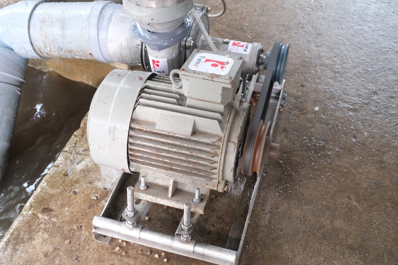 Mô tơ và bầu bơm tuhit FarmX F1 bắt trên khung inox tại khu chạy thử, dây cu roa nối hai pu li