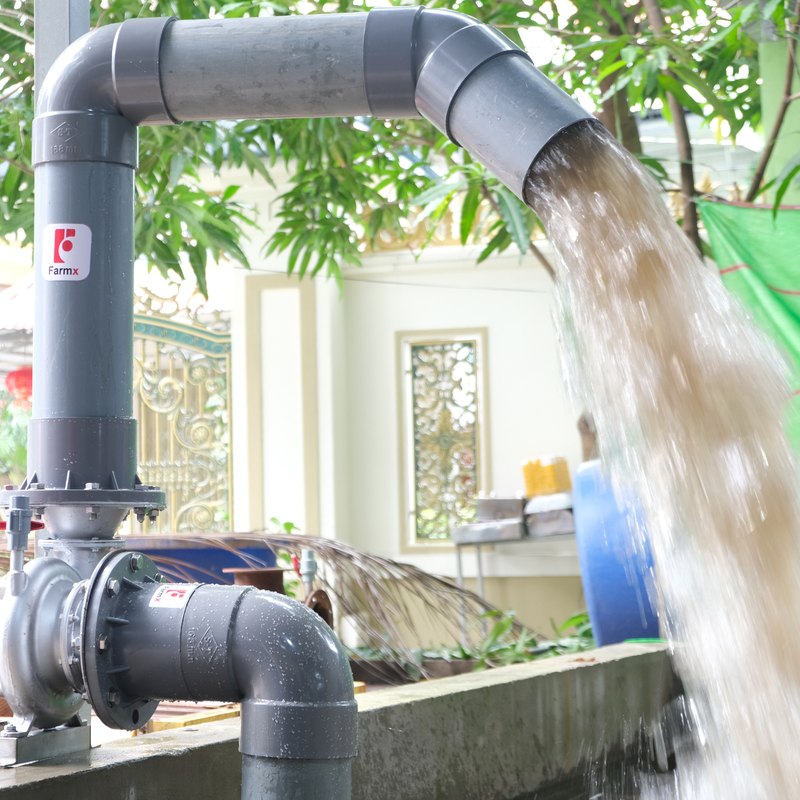 Máy bơm nước FarmX F1 MG168 liền mô tơ đang chạy, nước xả mạnh qua ống nhựa PVC xuống ao, xưởng FarmX Đầm Dơi Cà Mau