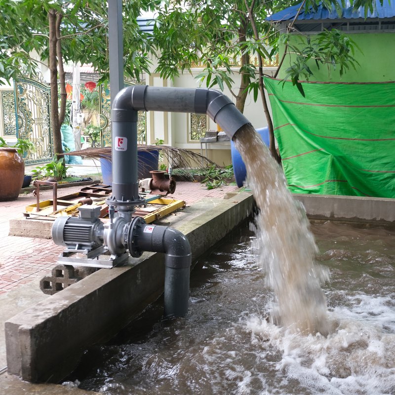 Toàn cảnh máy bơm nước FarmX F1 MG168 liền mô tơ đặt mé ao, nước xả tràn mạnh xuống mặt nước, xưởng FarmX Đầm Dơi Cà Mau