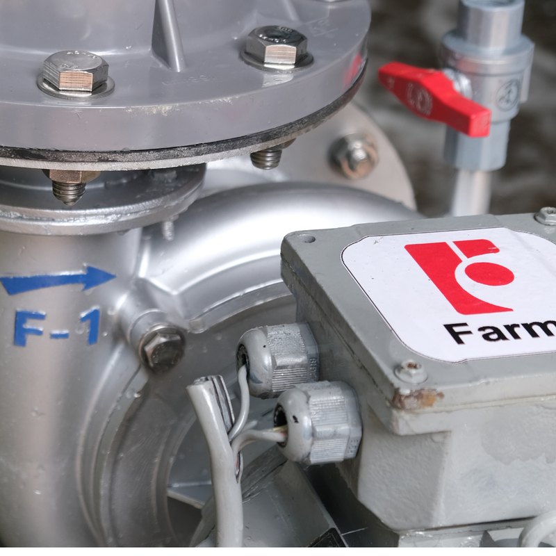 Cận cảnh thân máy bơm nước FarmX F1 MG168 liền mô tơ, khắc chữ F-1 kèm mũi tên chiều quay, bên phải là hộp đấu điện dán nhãn FarmX, xưởng FarmX Đầm Dơi Cà Mau